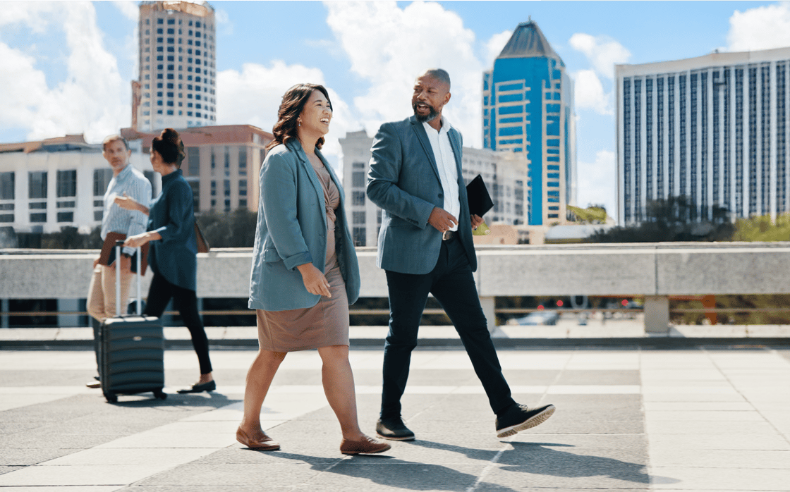 Business people walking on a sidewalk with city scape of Orlando, Florida in background